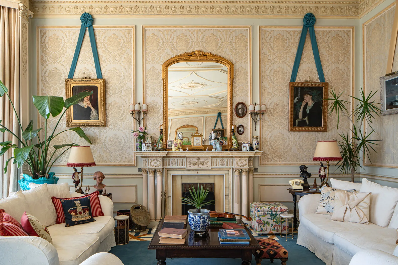 The drawing room fireplace at Wylam House &mdash; mantelpiece, gilt mirror and family portraits under teal ribbons